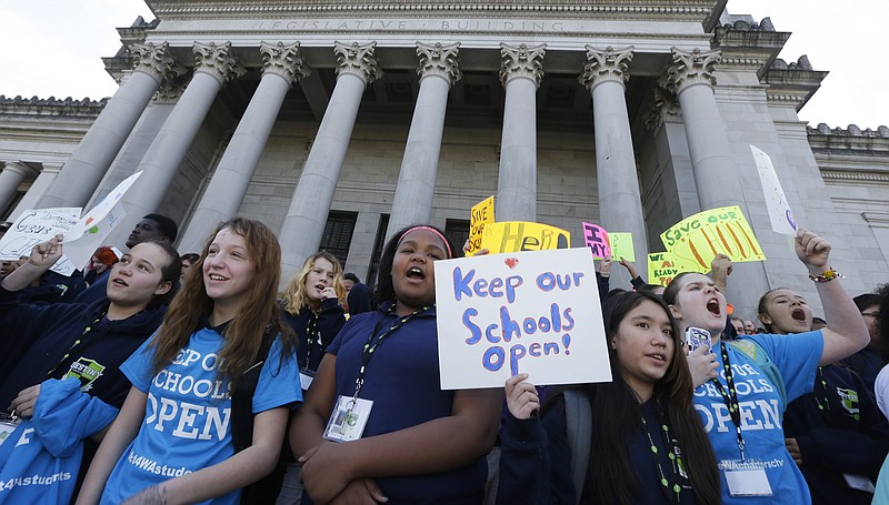 FILE - In this Feb. 25, 2016, file photo, children hold signs during a rally in support of public charter schools at the Capitol in Olympia, Wash. Support for charter schools has fallen significantly over the past year, according to a national opinion poll. Only 39 percent of respondents say they support the formation of charter schools, compared to 51 percent last year. The study was released by Education Next, an education journal published by Harvard’s Kennedy School and Stanford University. (AP Photo/Ted S. Warren, File)