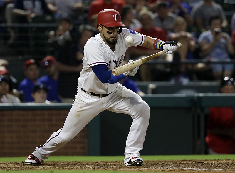 Texas Rangers' Robinson Chirinos lays down a sacrifice bunt Monday during the fourth inning against the Detroit Tigers in Arlington, Texas. The play moved Rougned Odor from second to third. 