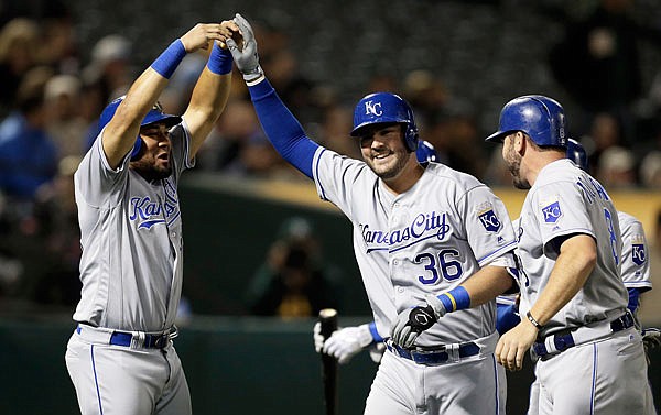 Cam Gallagher of the Royals is congratulated by Melky Cabrera (left) after hitting a grand slam off Athletics pitcher Jharel Cotton in the sixth inning of Monday night's game in Oakland, Calif.
