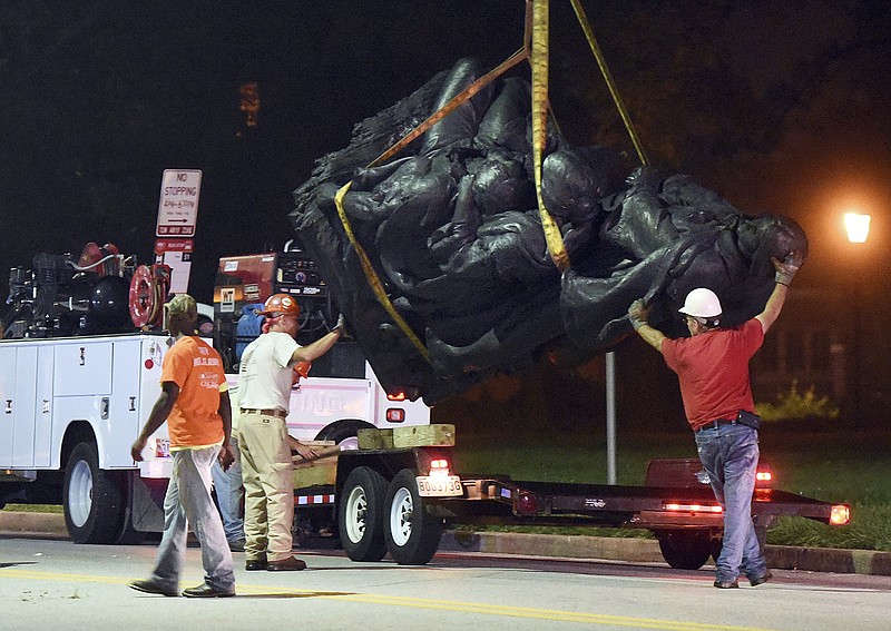 Workers remove a monument dedicated to the Confederate Women of Maryland early Wednesday, Aug. 16, 2017, after it was taken down in Baltimore. Local news outlets reported that workers hauled several monuments away, days after a white nationalist rally in Virginia turned deadly. (Jerry Jackson/The Baltimore Sun via AP)