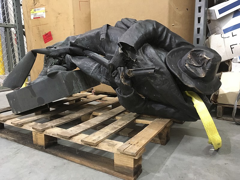 A damaged nearly century-old Confederate statue lies on a pallet in a warehouse in Durham, N.C. on Tuesday, Aug. 15, 2017. Investigators are working to identify and charge protesters who toppled the Confederate statue in front of a North Carolina government building, the sheriff said Tuesday. The Confederate Soldiers Monument, dedicated in 1924, stood in front of an old courthouse building that serves as local government offices. (AP Photo/Allen Breed)