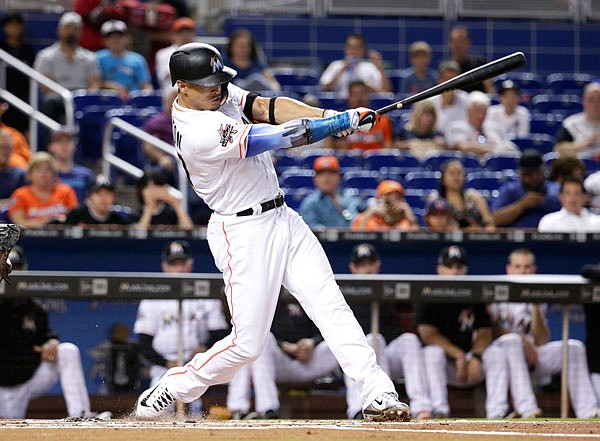 Marlins right fielder Giancarlo Stanton hits a single during the first inning of Tuesday night's game against the Giants in Miami.