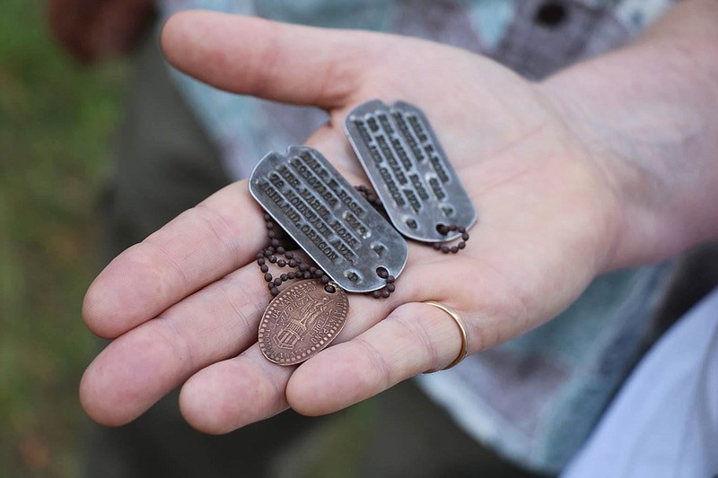 In this Aug. 3, 2017 photo, the dog tags and a Hawaiian pressed penny charm of Pfc. Dale W. Ross are displayed at Guadalcanal in the Solomon Islands. Ross, a North Dakota native, was assigned to the Army's 25th Infantry Division and was reported missing in action in January 1943 during the Guadalcanal campaign. (Justin Taylan/Pacific Wrecks via AP)