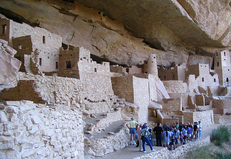 FILE - In this Aug. 27, 2005 file photo, visitors tour Cliff Palace, an ancient cliff dwelling in Mesa Verde National Park, Colo. Researchers say they have new evidence that ancestral Pueblo people who disappeared from the Mesa Verde cliff dwellings of southwestern Colorado 700 years ago migrated to what is now New Mexico. DNA from the bones of domesticated turkeys. The turkey DNA shows Native American people in the Rio Grande Valley of northern New Mexico raised and ate the same genetic strain of bird as the Mesa Verde people, and that the turkeys arrived in New Mexico about the same time Mesa Verde was abandoned, the researchers said. (AP Photo/Beth J. Harpaz,File)