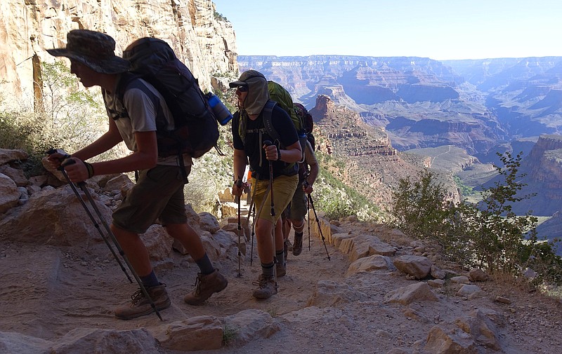 FILE - In this July 27, 2015, file photo, a long line of hikers head out of the Grand Canyon along the Bright Angel Trail at Grand Canyon National Park, Ariz. The U.S. federal government announced Wednesday, Aug. 16, 2017, it will eliminate a policy it put in place to allow national parks like the Grand Canyon to ban the sale of bottled water in an effort to curb litter. (AP Photo/Ross D. Franklin, File)