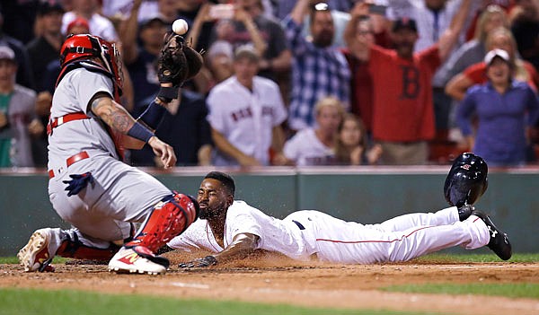 Jackie Bradley Jr. of the Red Sox slides home as the ball gets away from Cardinals catcher Yadier Molina while scoring on the game-winning, two-run double by Mookie Betts during the ninth inning of Wednesday night's game in Boston.