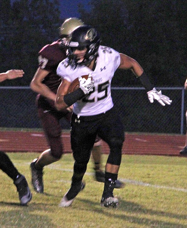 Versailles running back Grant Hutchison tries to scamper out of the backfield during a game last season at Eldon.