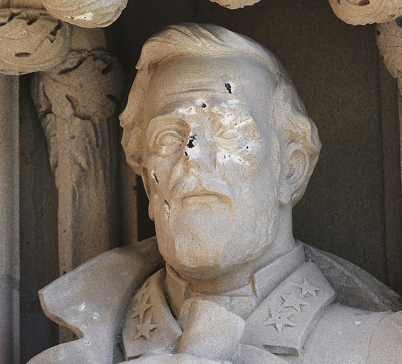 FILE - In this Aug. 17, 2017 file photo, the defaced Gen. Robert E. Lee statue stands at the Duke Chapel on Thursday, Aug. 17 2017, in Durham, N.C.  Duke University removed a statue of Gen. Robert E. Lee early Saturday, Aug. 19, days after it was vandalized amid a national debate about monuments to the Confederacy.  The university said it removed the carved limestone likeness early Saturday morning from Duke Chapel where it stood among 10 historical figures depicted in the entryway (Bernard Thomas/The Herald-Sun via AP)
