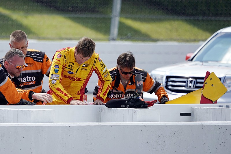 Ryan Hunter-Reay is helped from his car after wrecking during qualifying for Sunday's IndyCar auto race, Saturday, Aug. 19, 2017, in Long Pond, Pa. (AP Photo/Matt Slocum)