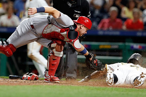 Cardinals catcher Carson Kelly misses the tag as the Pirates' Sean Rodriguez scores on a double by Josh Bell in the eight inning of Friday night's game in Pittsburgh.