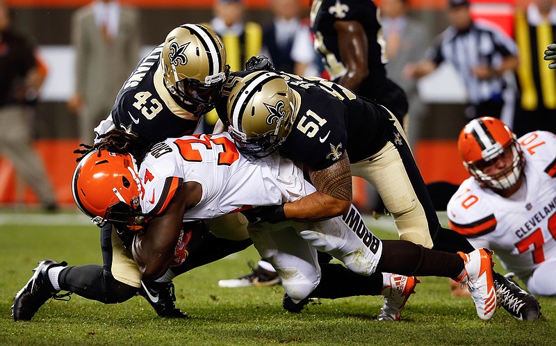 In this Aug. 10, 2017, file photo, Cleveland Browns running back Isaiah Crowell (34) is tackled by New Orleans Saints linebacker Manti Te'o (51) and Marcus Williams (43) during the first half of an NFL preseason football game in Cleveland. Te'o signed with the Saints during the offseason after four years with the San Diego Chargers. 