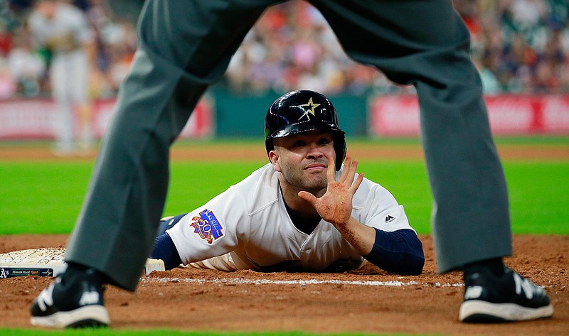 Houston Astros' Jose Altuve signals to first base umpire Dan Bellino after a pickoff-attempt by Oakland Athletics pitcher Ryan Dull in the eighth inning of a baseball game Saturday, Aug. 29, 2017, in Houston. 
