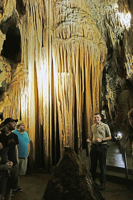 Bridal Cave guide, Joel Jones, speaks to a tour group in front of
the "pipe organ" stalactite formation in the Bridal Chapel chamber,
where about 3,500 weddings have been held since 1949.