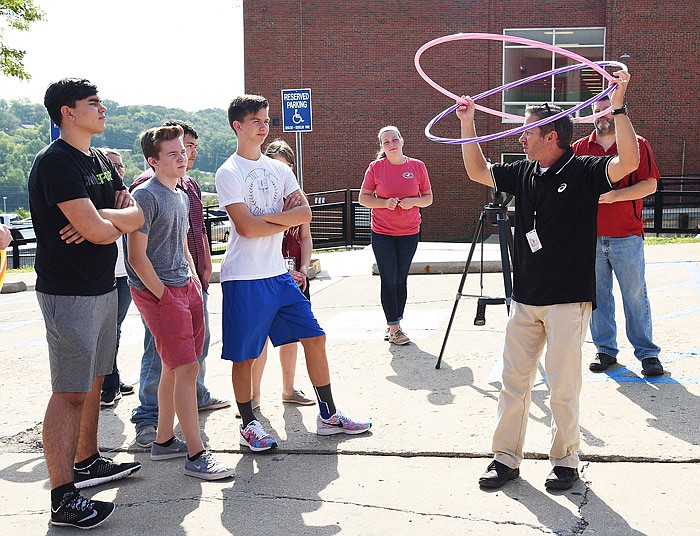 Jefferson City High School students in David Ganey and Rick Hirst's astronomy class watch Friday, Aug. 18, 2017 as Ganey demonstrates how an eclipse works with two hula hoops.