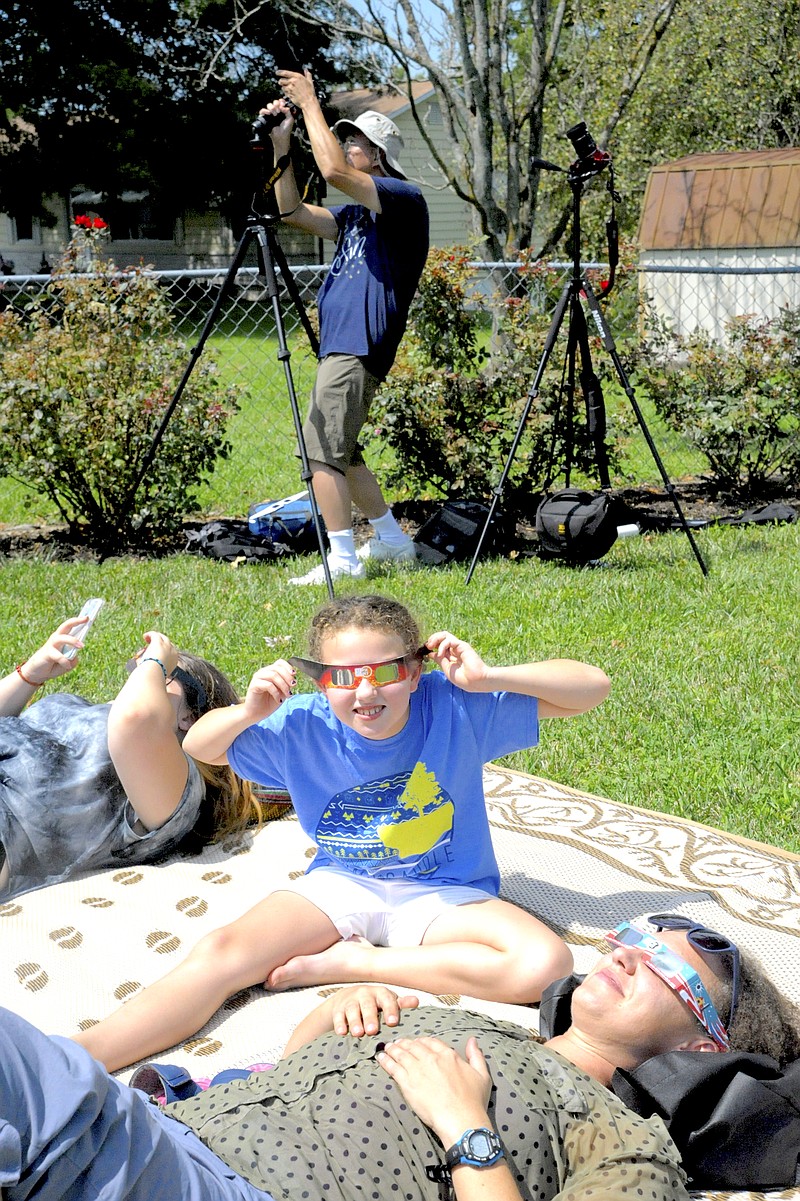 <p>Democrat photo/Michelle Brooks</p><p>Wichita, Kansas, amateur photographer Dick Woo sets up his time-elapse camera waiting for the total solar eclipse in Russellville’s Railroad Park, as Janna Martin and daughter Maddy and Ruby, from Russellville, Arkansas, view the partial coverage of the sun by the moon through protective lenses, prior to the full event.</p>