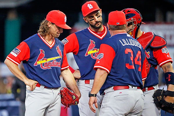 Cardinals pitching coach Derek Lilliquist visits starting pitcher Mike Leake as first baseman Matt Carpenter and catcher Yadier Molina listen in during the first inning of Sunday night's Little League Classic against the Pirates at Bowman Field in Williamsport, Pa.