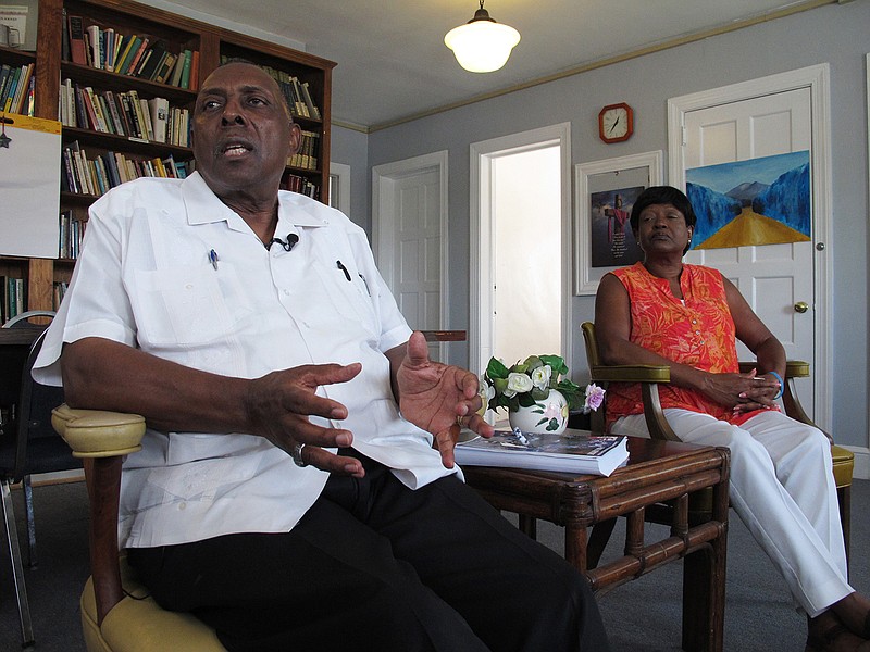 In this Wednesday, Aug. 16, 2017 photo, the Rev. Nelson Johnson and his wife, Joyce, talk about the 1979 "Greensboro Massacre" at his Faith Community Church in Greensboro, N.C. Johnson still has a faded scar on his left arm, left by a Nazi who attacked him.