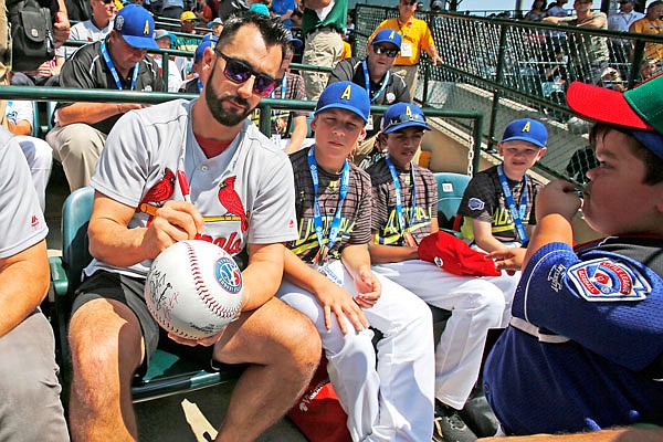 Cardinals first baseman Matt Carpenter signs a giant baseball while he sits with members of the Little League team from Australia at Lamade Field during Sunday's game between Fairfield, Conn., and Lufkin, Texas in United States pool play at the Little League World Series in South Williamsport, Pa.