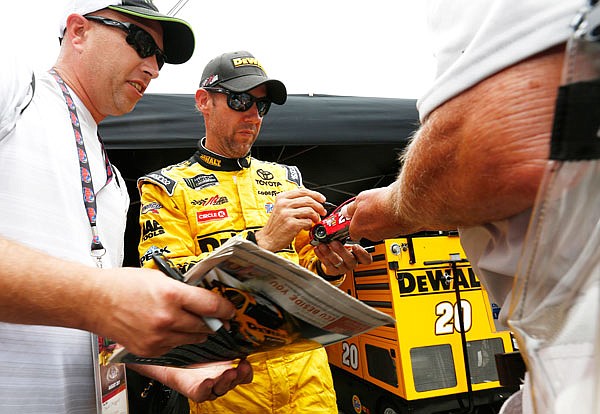 Matt Kenseth signs autographs for fans after Friday's practice for the NASCAR Cup Series race in Bristol, Tenn.