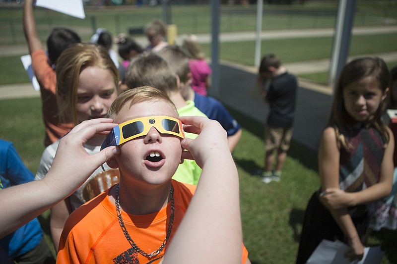 Hunter Coffee and other third-graders at Martha and Josh Morriss Mathematics & Engineering Elementary in Texarkana, Texas, take turns looking at the eclipse Monday. The students also used home camera obscuras to view the solar anomaly. While the eclipse was mostly visible in our area, in some parts of the country the opportunity to view the total eclipse drew thousands of visitors.