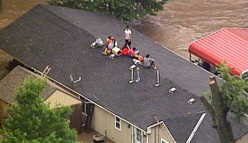 <p>AP</p><p>This aerial photo from a video by KCTV5 shows a family forced onto the roof of a home in Overland Park, Kansas, on Tuesday after heavy rains caused flash flooding in the Kansas City area. Flash flood warnings have been issued across the area.</p>