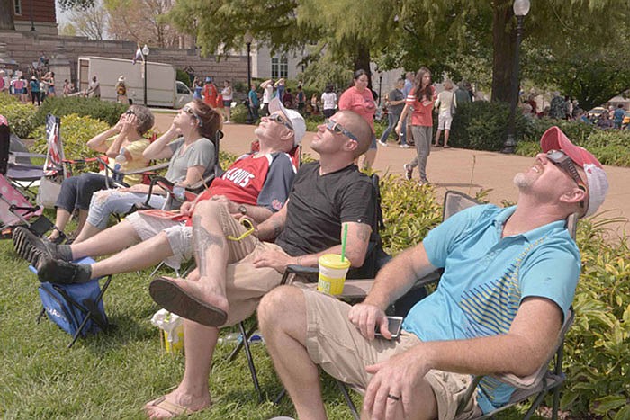 Chris Snodgrass, along with thousands of others, leans back to watch the eclipse on the south lawn of the Missouri Capitol.

