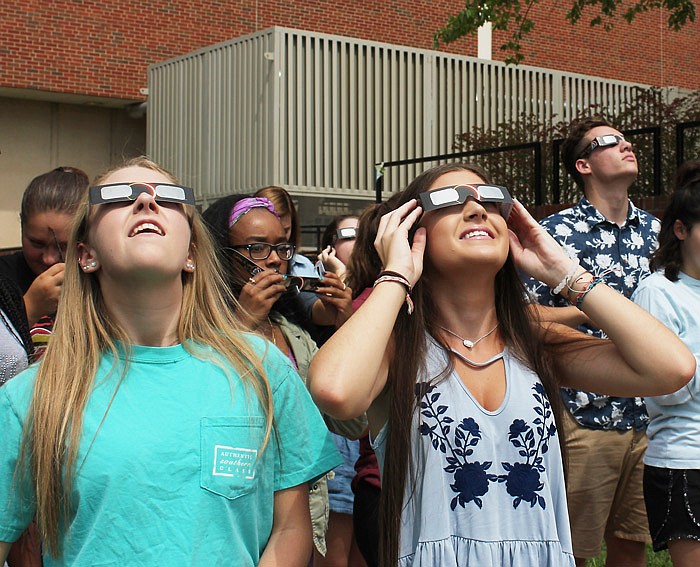 Students at Jefferson City High School took part in the festivities surrounding the total solar eclipse Monday, Aug. 21, 2017. Donning the necessary safety glasses, students went outside to the stadium to view the occurrence. Here, Samantha Tambke, foreground left, and Payton Burcham join fellow students outside the high school building. 
