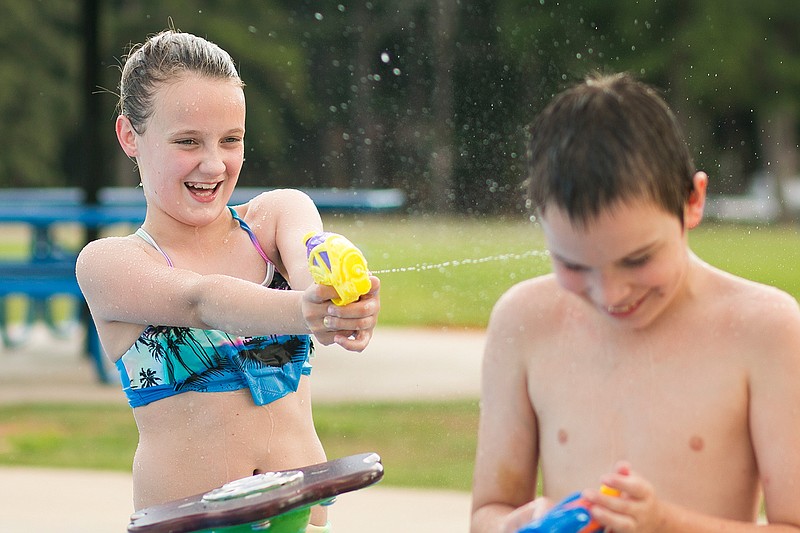 Hailey Perdue, 10, sprays Timothy Thornton, 8, with a water gun on Tuesday during their first time at the Spring Lake Park Splash Pad since school started. Hailey and Timothy both enjoyed the splash pad and were excited to enjoy some afternoon fun after school.