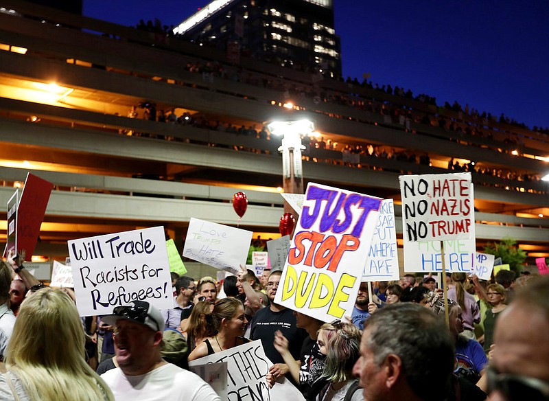 People protest outside the Phoenix Convention Center, Tuesday, Aug. 22, 2017, in Phoenix. Protests were held against President Donald Trump as he hosted a rally inside the convention center. 