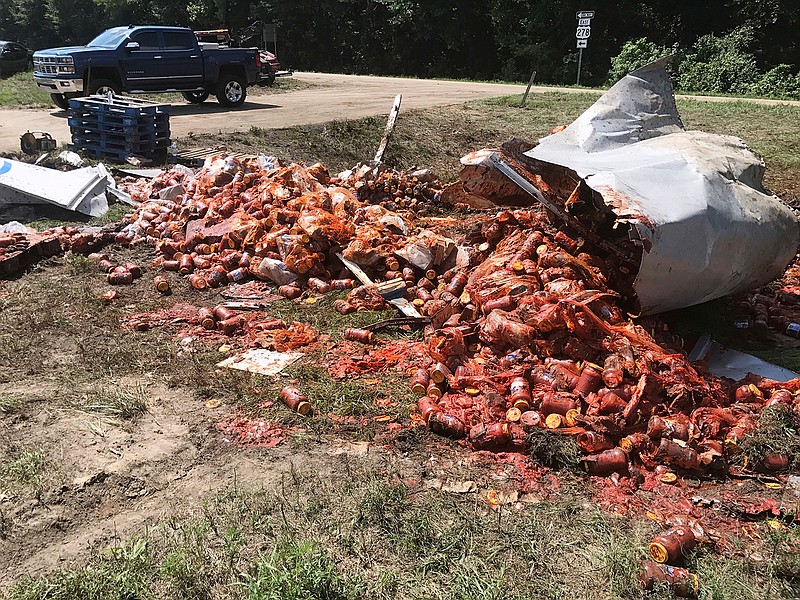 In this Monday, Aug. 21, 2017, photo provided by the Camden News, broken jars of spaghetti sauce litter a road near Camden, Ark. The crash marked the third time this month that edible goods were left on an Arkansas highway. A tanker spilled bourbon on Interstate 40 in eastern Arkansas on Aug. 2, and on Aug. 9 a truck split open on Interstate 30 in Little Rock, spilling frozen pizza. 