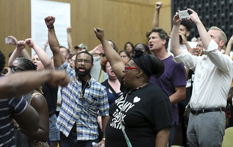 Protesters yell during the Charlottesville City Council meeting Monday, Aug. 21, 2017, in Charlottesville, Va. Anger boiled over at the first Charlottesville City Council meeting since a white nationalist rally in the city descended into violent chaos, with some residents screaming and cursing at councilors Monday night and calling for their resignations. 