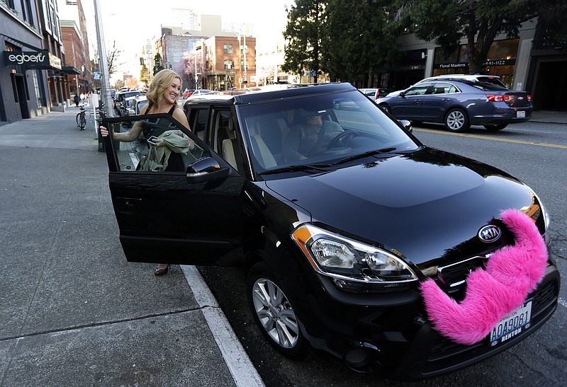 FILE - In this March 12, 2014 file photo, Katie Baranyuk gets out of a car driven by Dara Jenkins, a driver for the ride-sharing service Lyft, after getting a ride to downtown Seattle. For the second time this month, a federal judge has rejected a challenge to Seattle's first-in-the-nation law allowing drivers of ride-hailing companies such as Uber and Lyft to unionize over pay and working conditions, Thursday, Aug. 24, 2017. (AP Photo/Ted S. Warren, File)