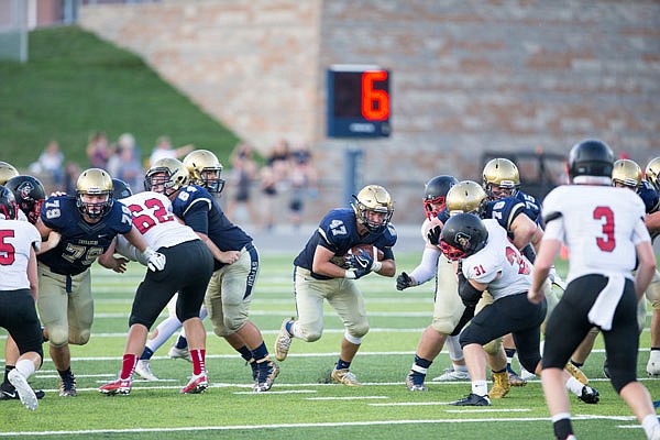 Helias running back Blake Savage heads through an opening at the line of scrimmage during last Friday night's game against the Hannibal Pirates at Ray Hentges Stadium.