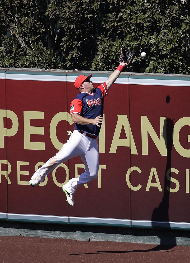 Los Angeles Angels' Mike Trout can't catch a triple hit by Houston Astros' Brian McCann during the eighth inning of a baseball game, Sunday, Aug. 27, 2017, in Anaheim, Calif.