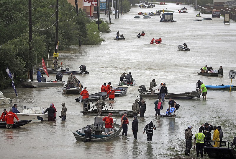 Rescuers in boats fill Tidwell Road on Monday as they help flood victims evacuate as floodwaters rise in Houston. 