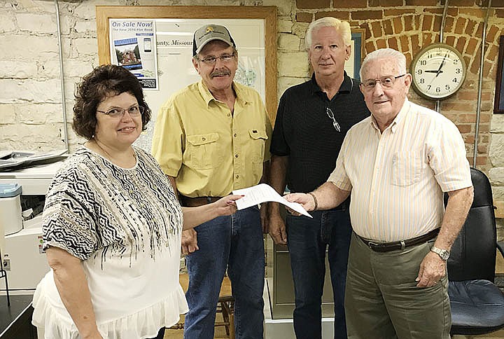 <p>Submitted</p><p>Moniteau County Clerk Roberta Elliott presents the county library initiative petition to Presiding Commissioner Kenneth Kunze. Behind them are District 1 Commissioner Noland Porter, left, and District 2 Commissioner Greg Robinson. The proposition was ordered placed on the November ballot Aug. 24.</p>