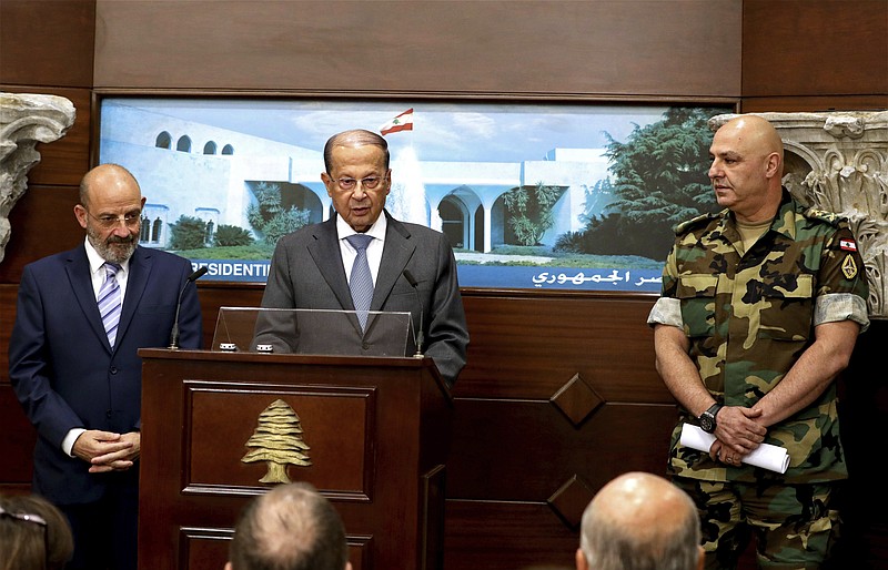 In this photo released by Lebanon's official government photographer Dalati Nohra, Lebanese Army Commander Gen. Joseph Aoun, right, and Spanish Defense Minister Yacoub Sarraf, left, listen to Lebanese President Michel Aoun, speaking to journalists at the Presidential Palace in Baabda, east of Beirut, Lebanon, Wednesday, Aug. 30, 2017. Aoun declared victory against the Islamic State group Wednesday in a live statement praising the Lebanese army for carrying out the operation that ended with the deal to evacuate IS fighters and their families in return for information about nine troops who were kidnapped by IS in August 2014. (Dalati Nohra via AP)