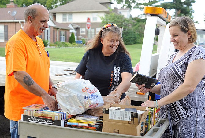 Louis Gerling, left, and Tracy Morrow of Scott's Towing drop of their collection of books Tuesday to librarian Melanie Thompson, right, at Thorpe J. Gordon Elementary School. Thompson had the idea to collect books to donate to those affected by Hurricane Harvey in Houston after seeing a post from her friend who is a teacher there.