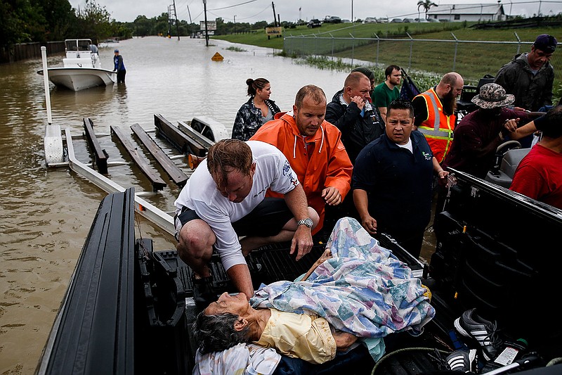 A rescuer moves Paulina Tamirano, 92, from a boat to a truck bed as people evacuate from rising waters from Tropical Storm Harvey, Tuesday, Aug. 29, 2017 in Houston. 