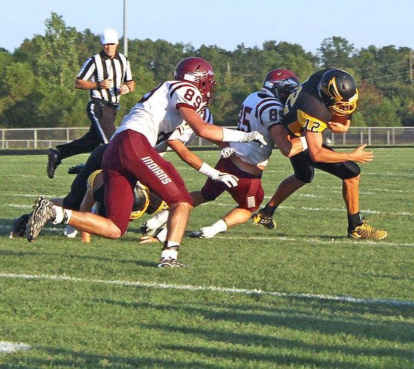 Fulton quarterback Evan Gray tries to break a tackle during the season opener against School of the Osage.