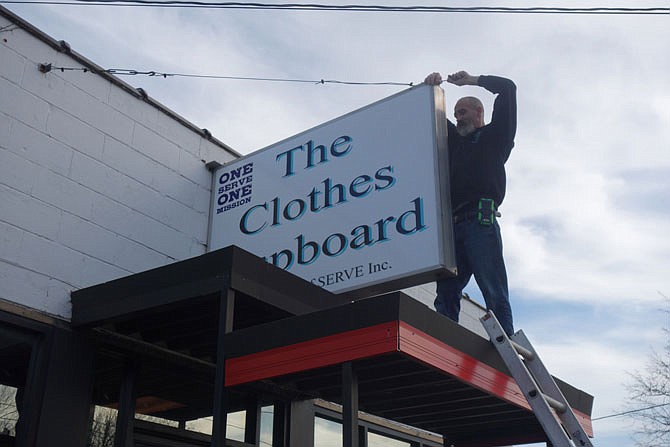 Rick Head mounts the Clothes Cupboard sign at their temporary location at 518 Jefferson St. The Serve Inc.-run operation will soon move to a large building at 1223 South U.S. Business 54.