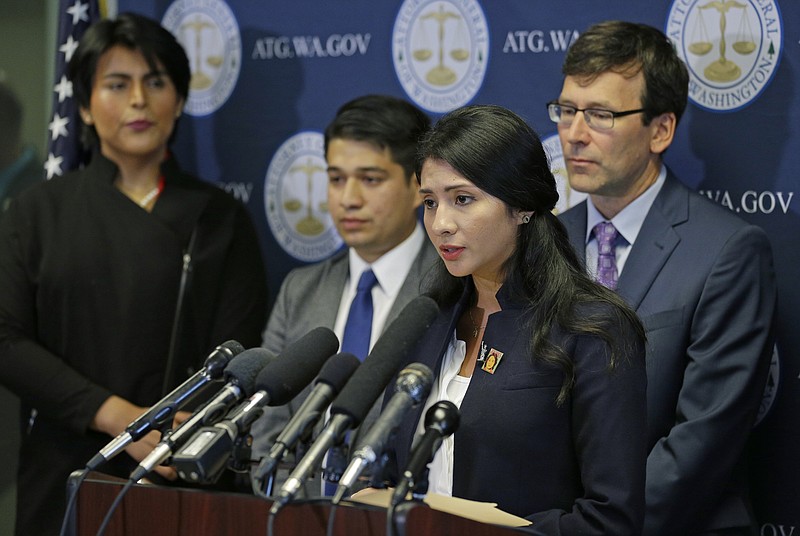 CORRECTS SPELLING OF LAST NAME TO FERGUSON, NOT FERGUS - Faride Cuevas, second from right, a participant in the Deferred Action for Childhood Arrivals, or DACA, program, talks to reporters, Wednesday, Sept. 6, 2017, in Seattle, as Washington Attorney General Bob Ferguson, right, and two other DACA participants look on. More than a dozen states and the District of Columbia filed a lawsuit Wednesday to block President Donald Trump's plan to end a program protecting young immigrants from deportation, after U.S. Attorney General Jeff Sessions said Tuesday that DACA will end in six months to give Congress time to find a legislative solution for the immigrants. (AP Photo/Ted S. Warren)