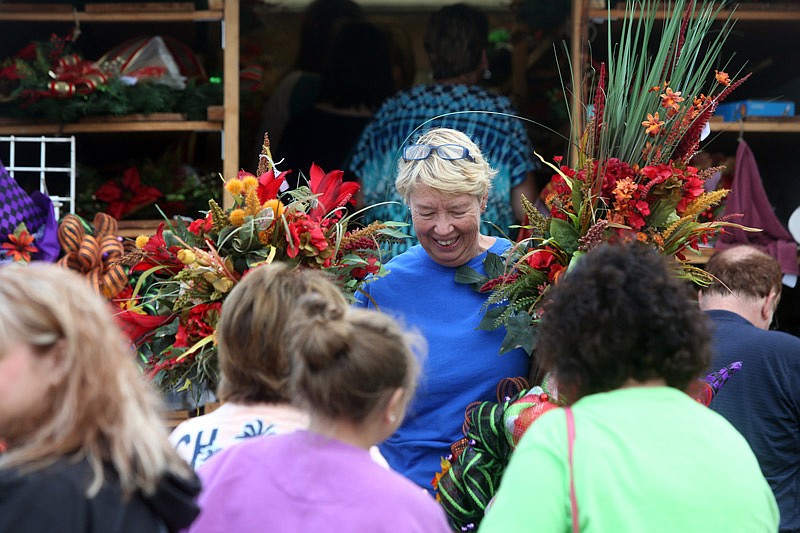 Sophia Kroll comes out of a stand bearing fall wreaths during the Cole County Extension's 40th Fall Festival held at the Jaycees fairgrounds in Jefferson City, Missouri on Saturday September 9, 2016.