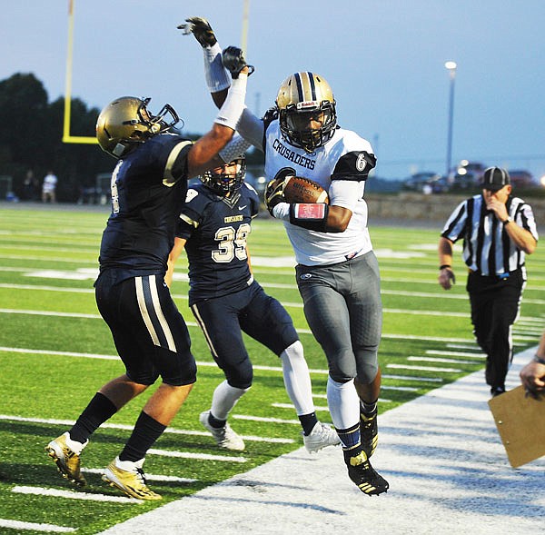 Helias teammates Adam Wilbers (left) and Ethan Holzhauser force Justin Strong of Althoff out of bounds during last Friday night's game at Ray Hentges Stadium.