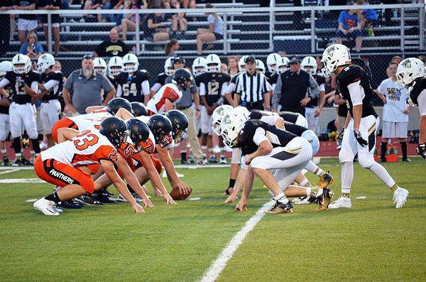 The Versailles defense lines up for a play during its season opener against Knob Noster last month in Versailles.