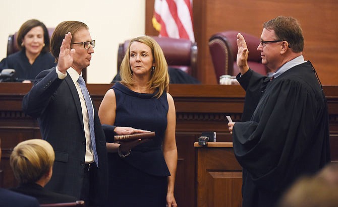 With his wife, Beth Phillips, by his side, W. Brent Powell, left, repeats the oath of office Friday as administered by Chief Justice, Zel M. Fischer, while being sworn in as the newest justice on the Missouri Supreme Court.