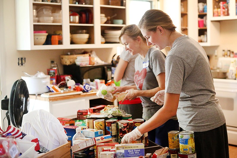 Brittney Kauffman, front, organizes Judy Howard's kitchen Saturday, Sept. 9, 2017
during a Both Hands event, which raises funds and performs services
for orphans, widows and adoptive families.