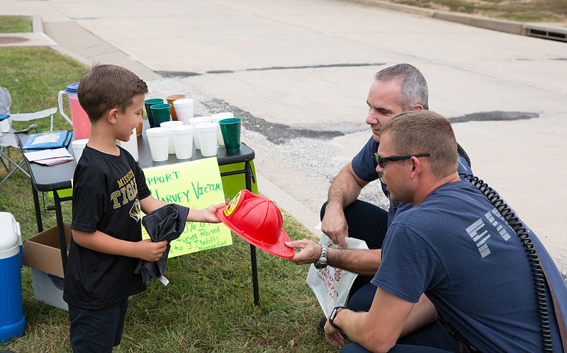 Hudson Patrick gets a visit Saturday, Sept. 9, 2017
by Jefferson City firemen Ryan Back,
right, and Ron Smith at his lemonade
stand.