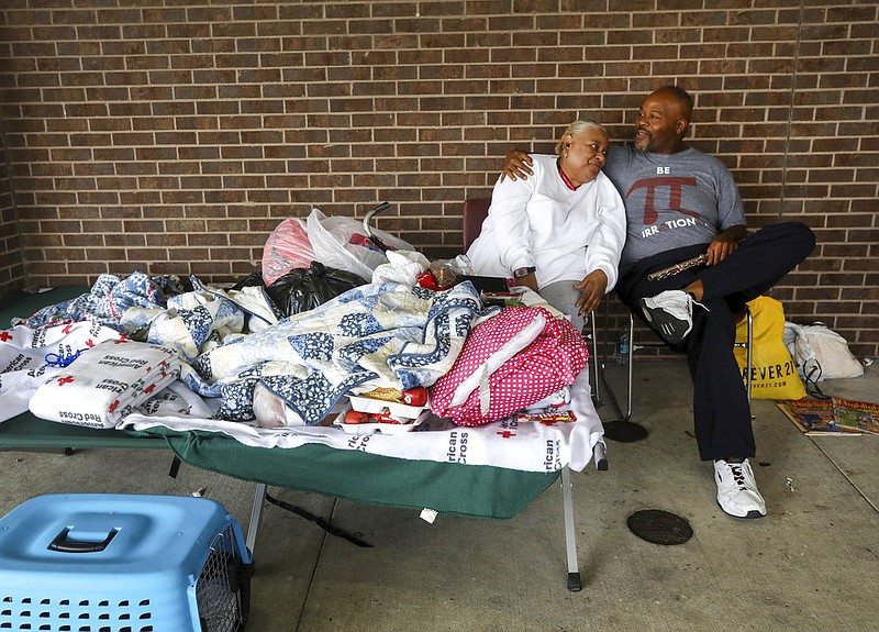 James Ward, right, a music student at Sam Houston Sate University, attempts to make Vivian Williams smile, at a Red Cross shelter at W. W. Thorne Stadium, Tuesday, Aug. 29, 2017, in Houston. Ward, who lived through Hurricane Katrina, said, "We've been blessed, people need smiles." ( Jon Shapley/Houston Chronicle via AP)