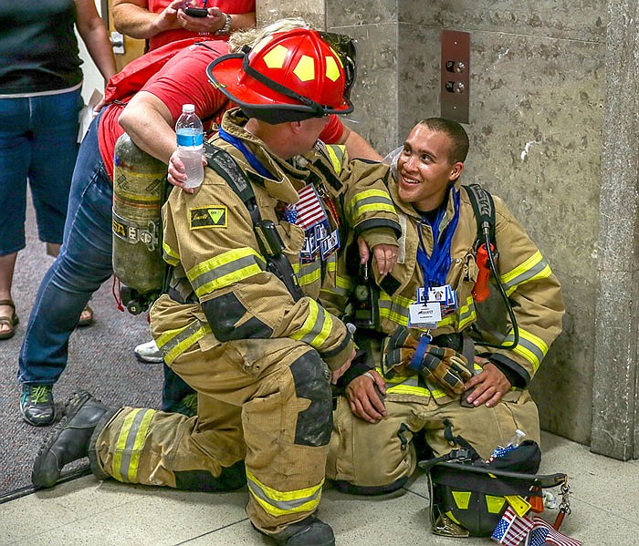 DeeDee Edwards, of the State Fire Marshals office, talks with firefighters Donovan Cope (red helmet) of Hazlegreen Fire Department, and Tylor Brown, of St. Robert Fire Department, as they take a breather during the climb.